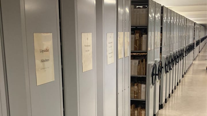 Rullarkiv med handhjul och etiketter – lång gång i arkivmagasin